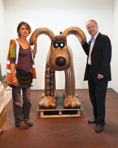 The Gromit sculpture. On the left its creator, Newport artist Stephanie Roberts; on the right The Royal Mint?s Chief Engraver, Gordon Summers. © The Royal Mint.