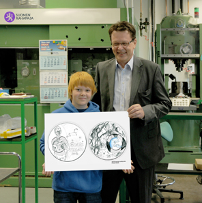 The raffle?s official superviser Ricky Rapper (actor Severi Heikkilä) and Mint of Finland?s CEO Paul Gustafsson are showing the winning design of the Children and Creativity competition.