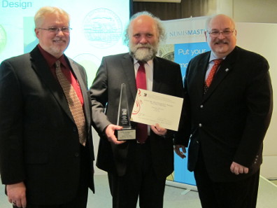 Herbert Wähner (at center) accepts the prize from the hands of Tom Michael and George Cuhaj. Photograph: UK.