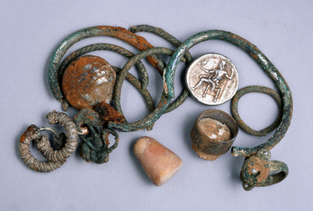 A general picture of the cache of silver objects: two coins of Alexander of Macedon, three rings, four bracelets, two decorated earrings, three other earrings (probably made of silver) and a small stone weight. Photograph: Clara Amit. Courtesy of the Israel Antiquities Authority.