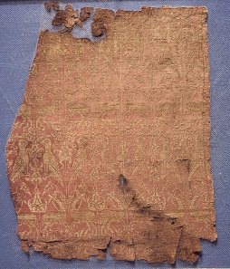Fragments of the funerary robe of Henry VI, red-and-gold lampas silk, tomb of Henry VI, Palermo, Sicily, AD 1197. © The Trustees of the British Museum.