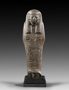 Lot 455: Tall ushabti. New Kingdom, ca. 1270-1080 BC. H 23 cm. Black basalt. From K.M. Collection, Thuringia. Estimate: 10,000,- euros. Hammer price: 20,000,- euros.