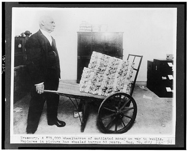 Employee with a wheelbarrow full of banknotes to be laundered, taken between 1909 and 1925. Photo: Library of Congress, Prints &Photographs Division (LC-USZ62-106975).