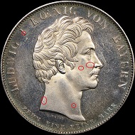 The obverses of two counterfeit 1825 Bavaria Coronation Thalers.