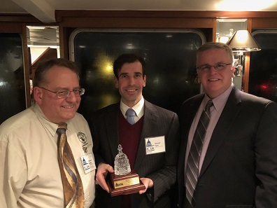 Industry Council for Tangible Assets chief operating officer David Crenshaw (right) and ICTA treasurer Patrick Heller (left), present Mitch Hyatt (center) with the organization’s Diane Piret Memorial Outstanding Service Award at the organization's dinner and update cruise.