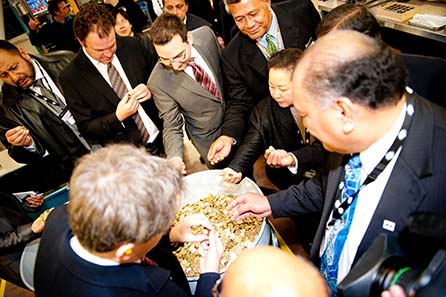 Guests looking at a drum full of two tala coins.