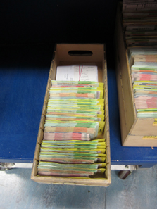 The money from the bags is distributed into cardboxes with cover sheets, ready for counting. Photo: UK.