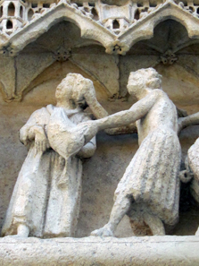 Detail of the Portal of San Nicola - A rich man is weighed down by his bag of money and being led away by a devil. Photo: KW.